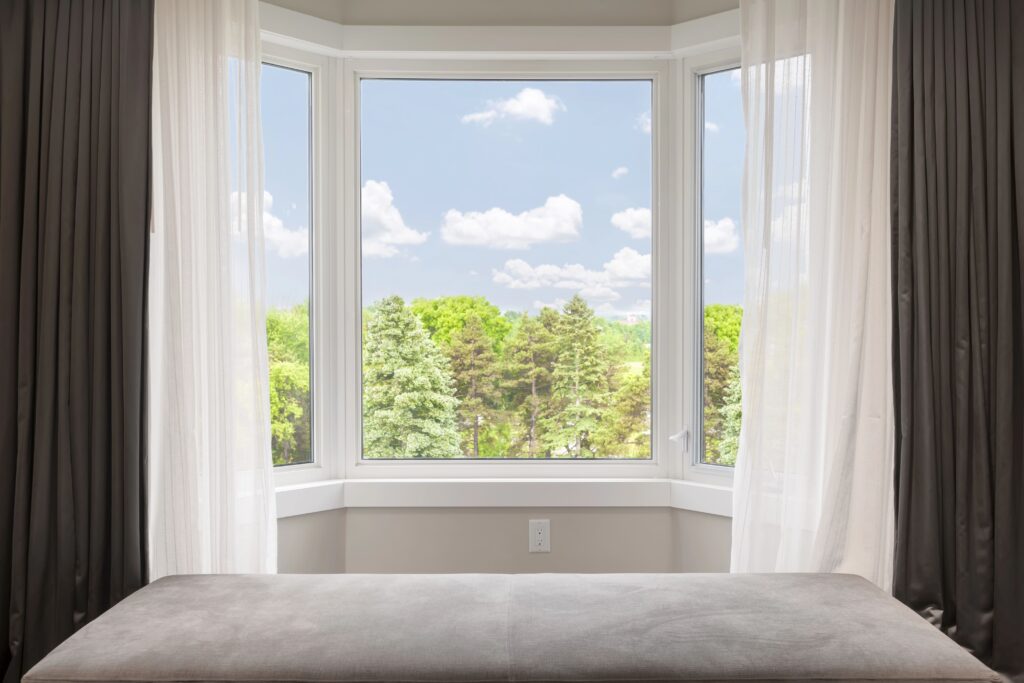 bay window across from bed with view of trees